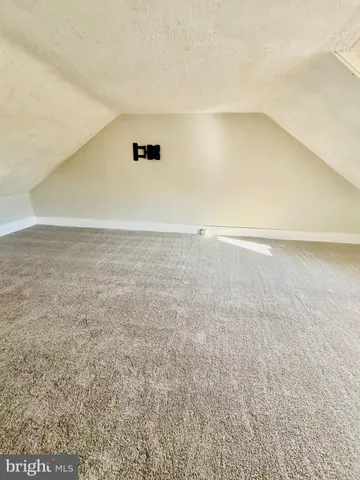 an empty room with a chandelier fan and windows