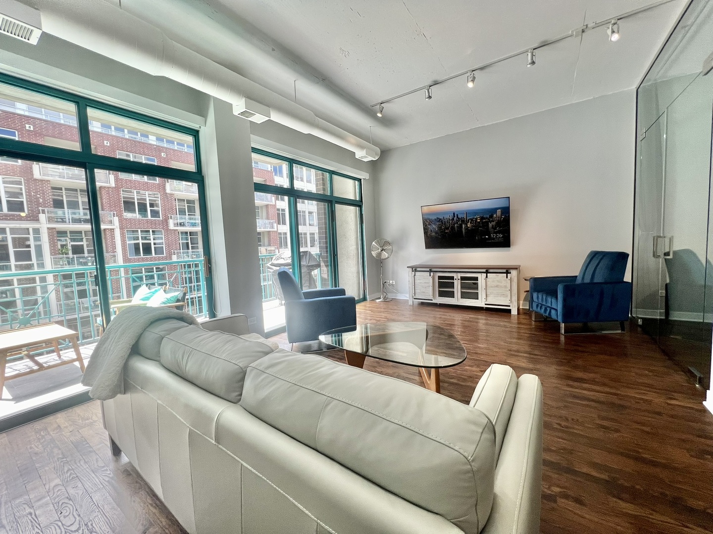 910 West Madison Street, Unit 602 Chicago, IL 60607 - Photo 3 of 13 a living room with furniture large windows and a flat screen tv