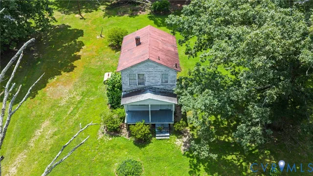 a aerial view of a house with a yard and large tree