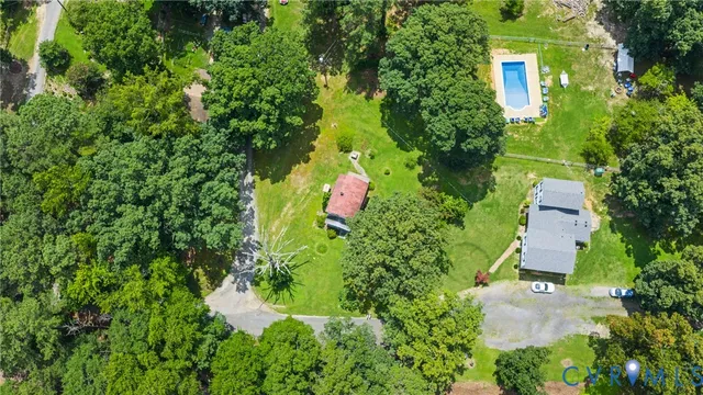 an aerial view of residential house with outdoor space and trees all around