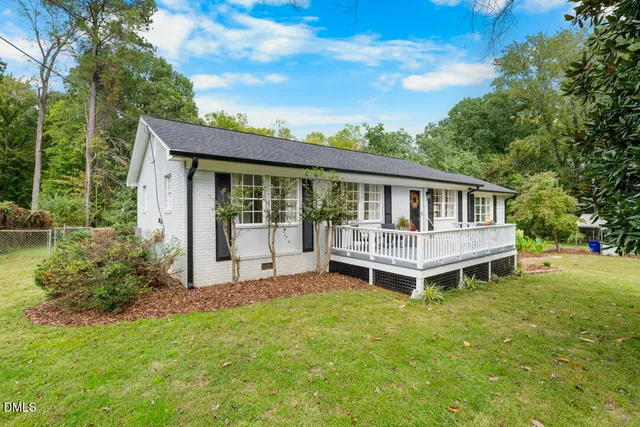 a view of a house with a yard and deck