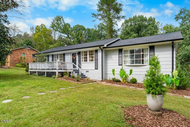 a view of a house with backyard and sitting area