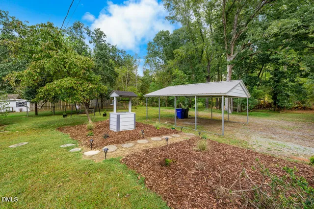 a view of patio with a table and chairs under an umbrella