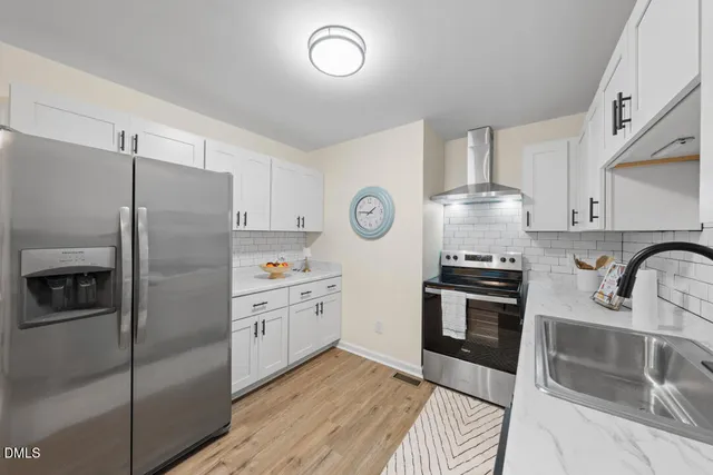 a kitchen with stainless steel appliances granite countertop a refrigerator sink and stove