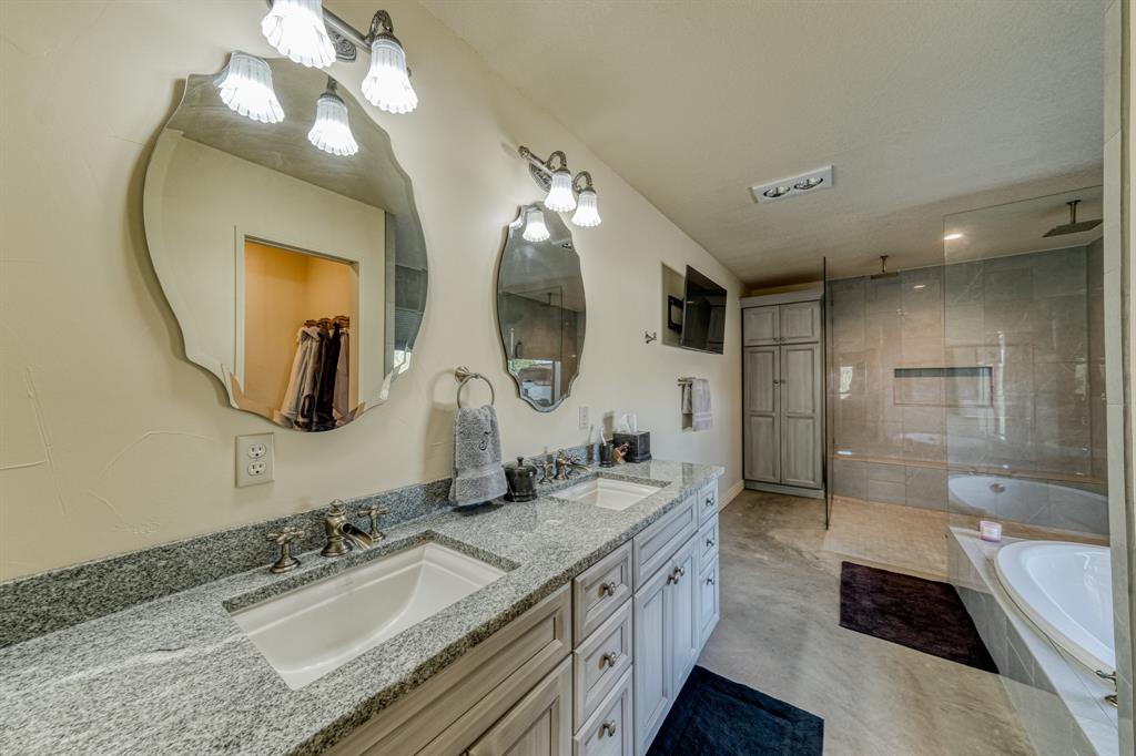 2337 Walsh Road Olney, TX 76374 - Photo 38 of 38 Double vanity with granite countertops, light-toned cabinetry, and decorative mirrors