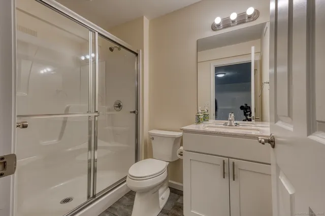 a bathroom with a sink a toilet and shower