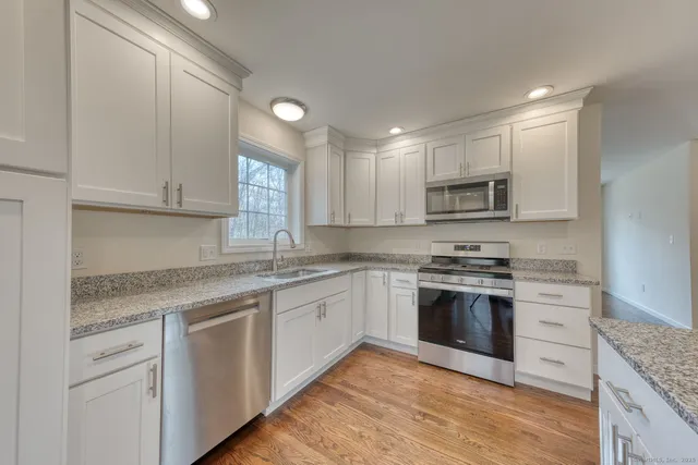a kitchen with granite countertop cabinets stainless steel appliances and a sink