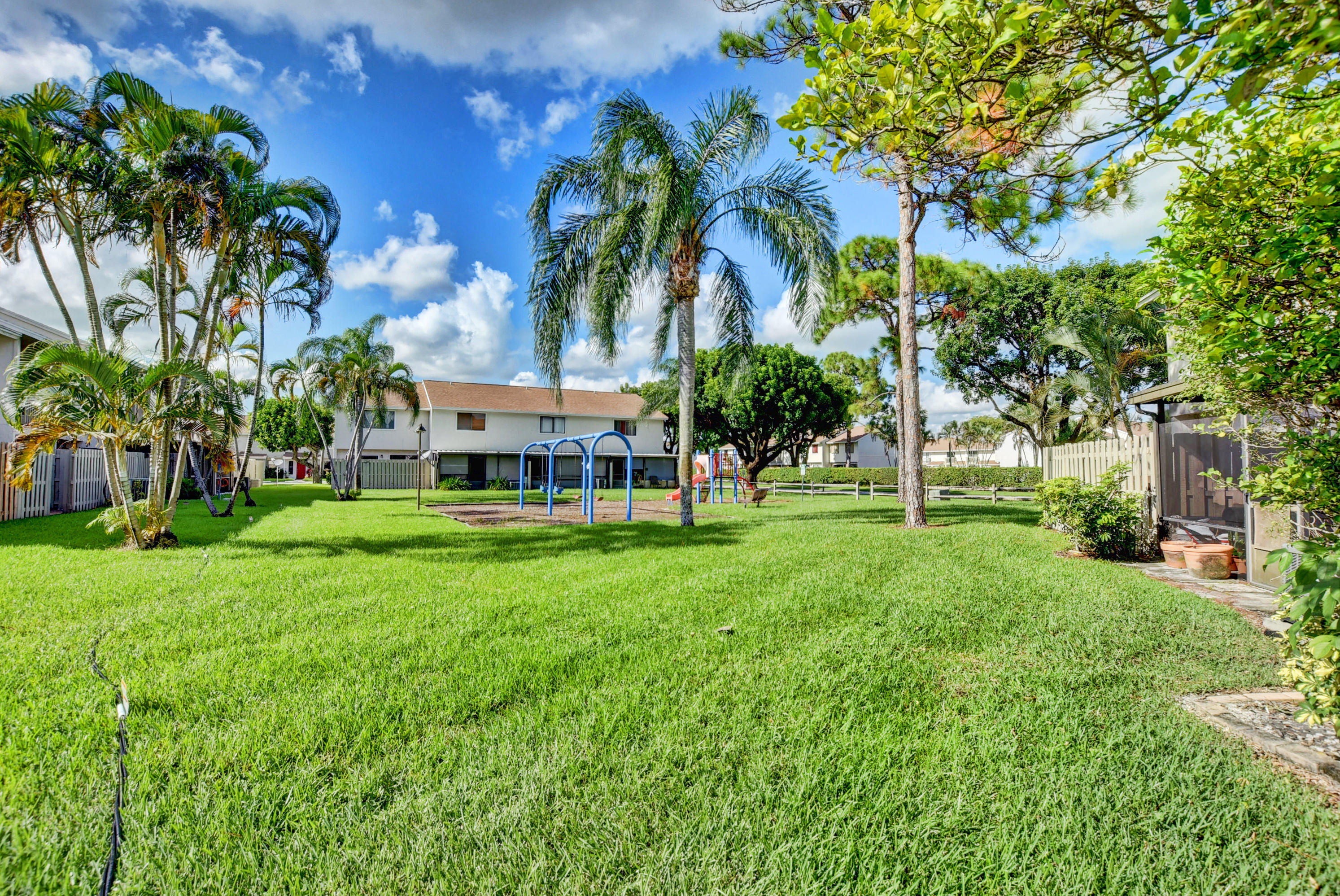 3603 Inlet Circle Greenacres, FL 33463 - Photo 30 of 34 a view of a house with a big yard and palm trees