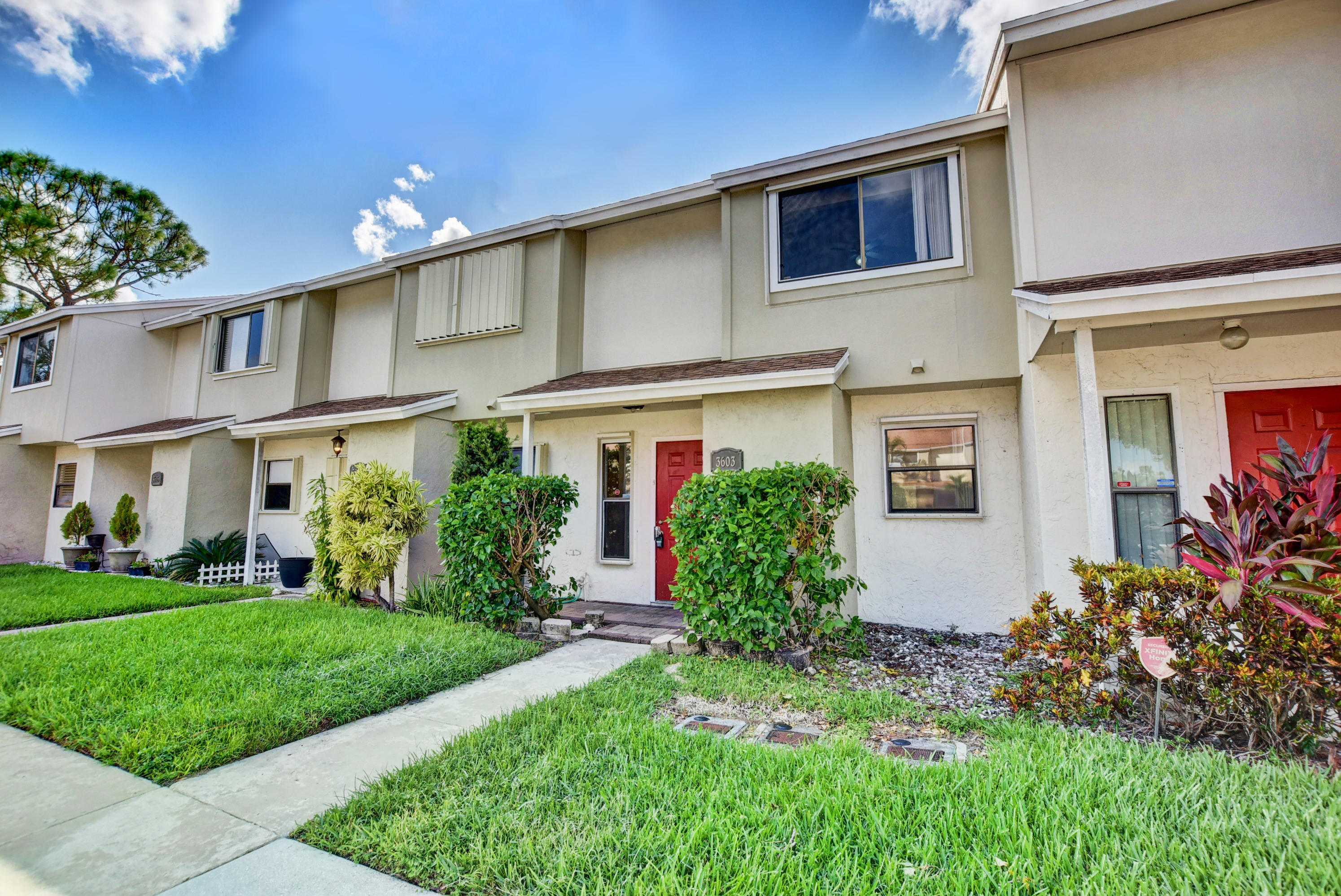 3603 Inlet Circle Greenacres, FL 33463 - Photo 3 of 34 a front view of a house with a yard and potted plants