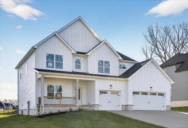 a view of a white house with a big yard and large windows