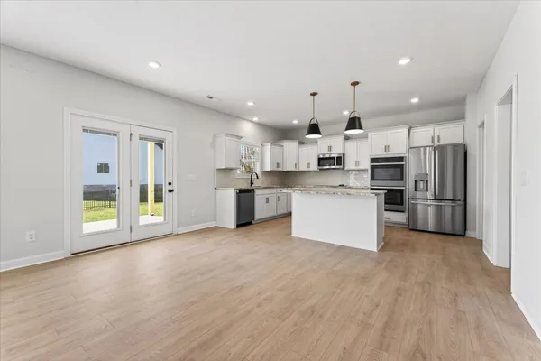 a large kitchen with stainless steel appliances granite countertop a stove and a refrigerator