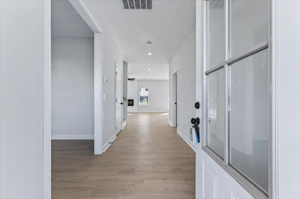 a view of a hallway with wooden floor
