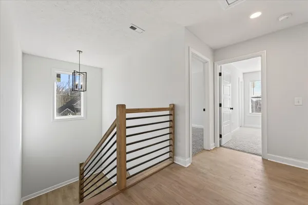 a view of a hallway with entryway and wooden floor