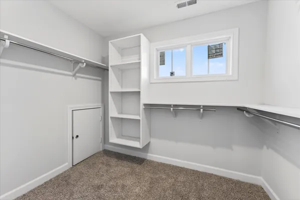 a view of an empty room with cabinet and a window