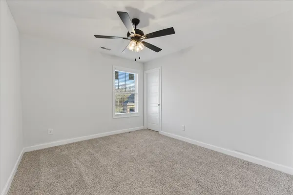 an empty room with a window and a fan
