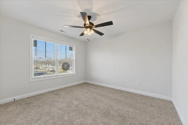 an empty room with a window and a fan