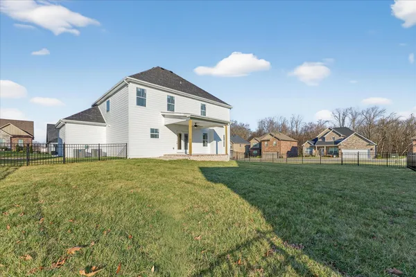 a view of a house with a big yard and large trees