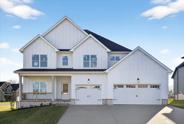 a view of a white house with a big yard and large trees