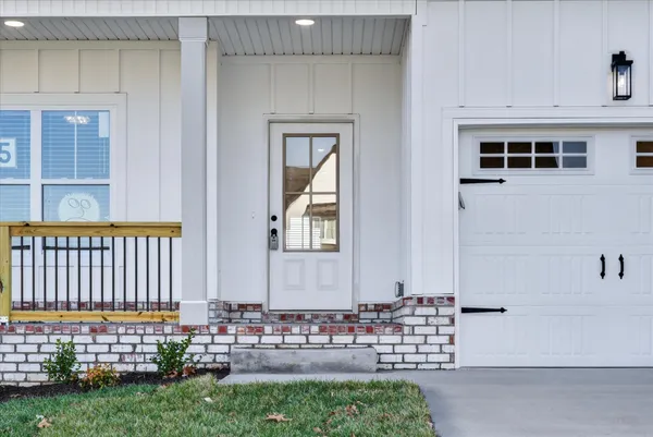 a view of a white house next to a yard