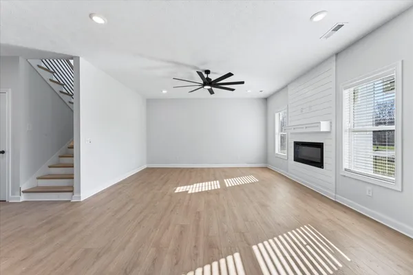 an empty room with a fireplace and wooden floor