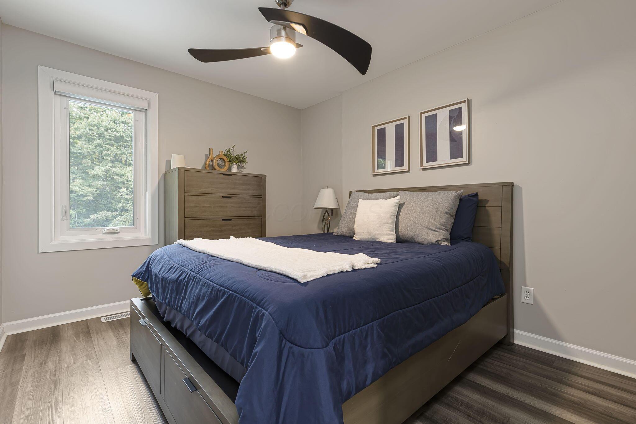 7140 Cook Road Powell, OH 43065 - Photo 57 of 87 Neutral wall color, wood-finish flooring, white window trim, and a ceiling fan with integrated lighting