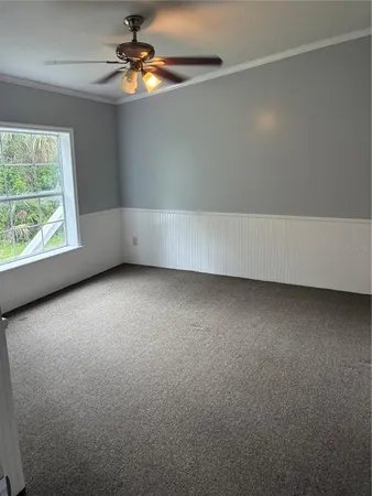 an empty room with a window and a ceiling fan