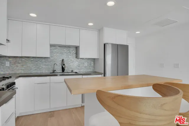 a kitchen with stainless steel appliances granite countertop a refrigerator and a sink