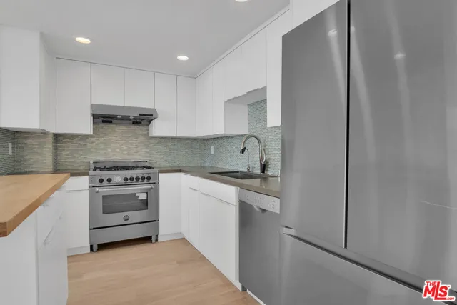 a kitchen with cabinets appliances and a sink