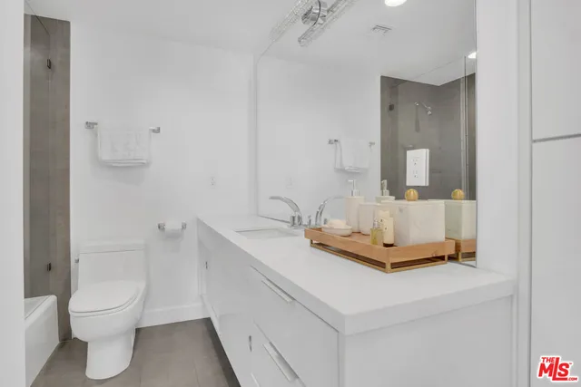 a bathroom with a sink toilet and mirror