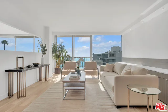 a living room with furniture and a floor to ceiling window
