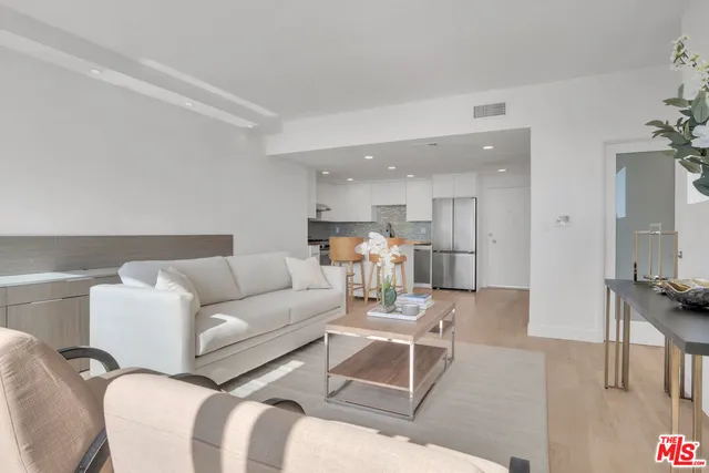 a living room with furniture and kitchen view