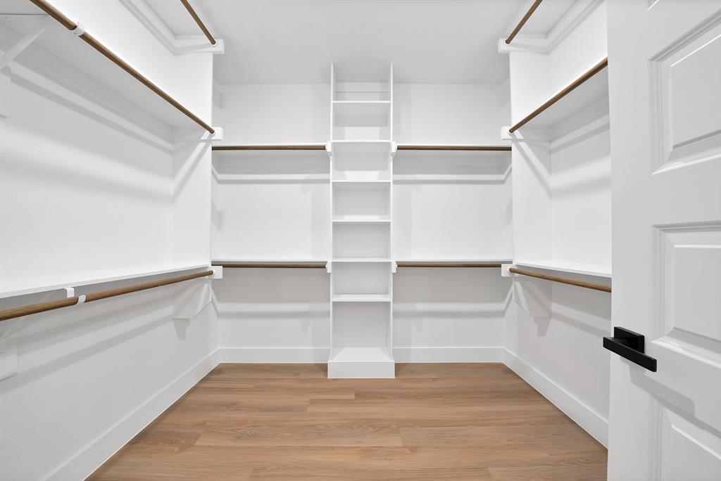 805 Tierney Road Fort Worth, TX 76112 - Photo 22 of 36 Walk-in closet with built-in shelving, hanging rods, and wood-finish flooring