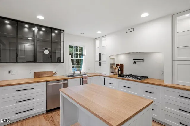 a kitchen with stainless steel appliances a sink stove and cabinets
