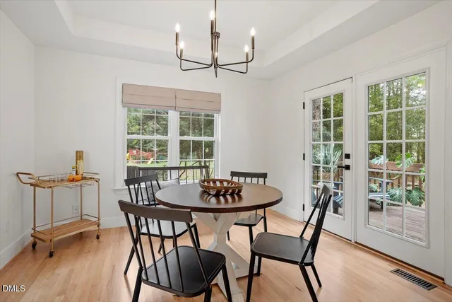 a dining room with furniture a chandelier and wooden floor