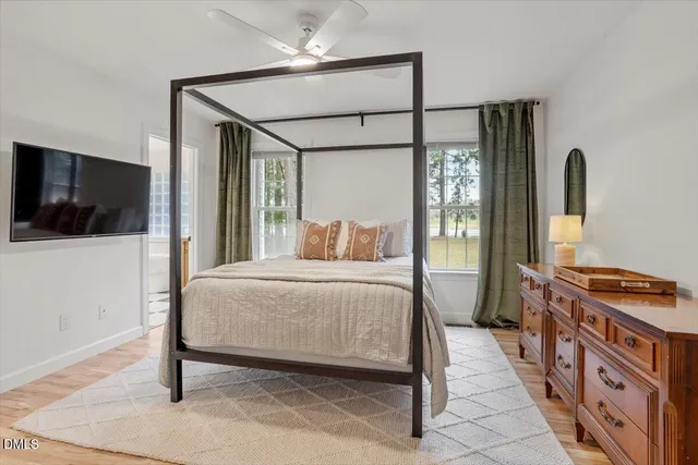 a bedroom with a bed and a flat tv screen on dresser