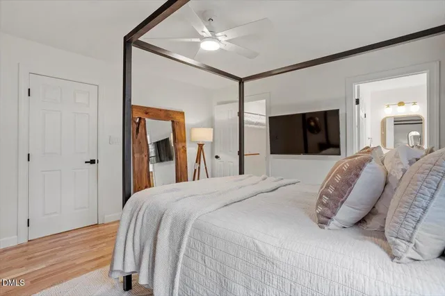 a bedroom with a large bed and a chandelier