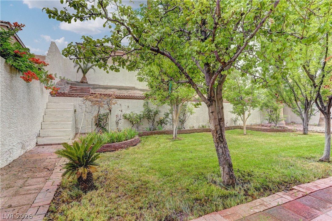 1813 Snow Spring Lane Las Vegas, NV 89134 - Photo 34 of 37 A verdant lawn and mature trees provide a private oasis in this backyard setting.