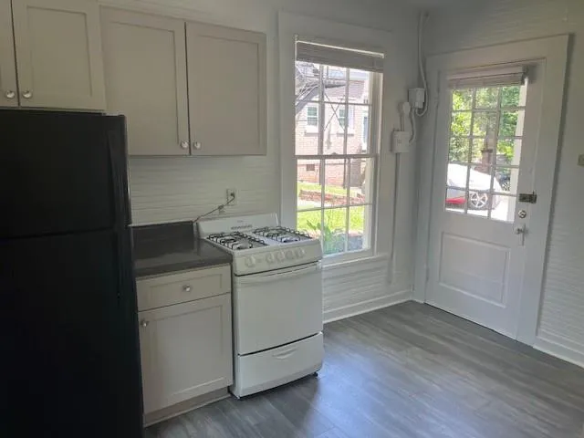 a kitchen with a sink and wooden floor