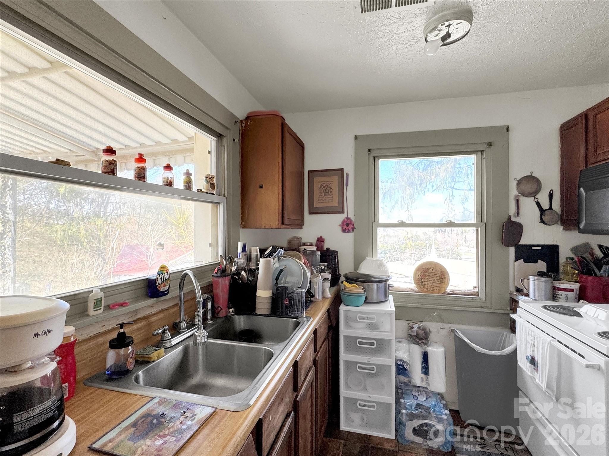 301 Mulberry Street Clyde, NC 28721 - Photo 6 of 23 a kitchen that has a sink a stove and a wooden floor