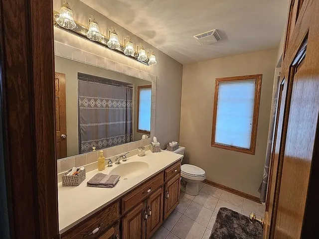 a bathroom with a sink vanity granite and toilet