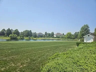 a view of a green field with wooden fence