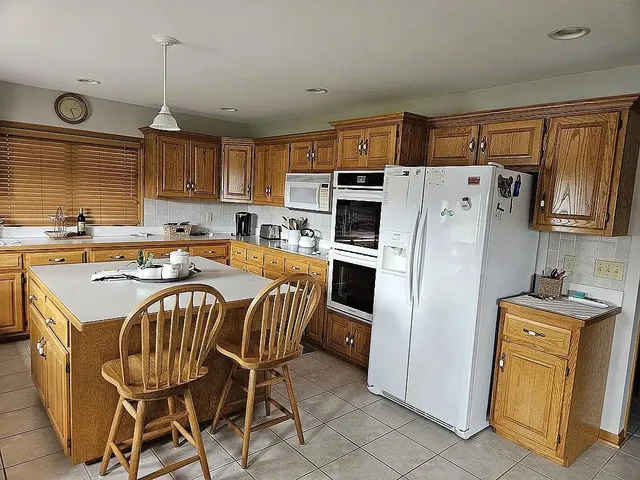 a kitchen with stainless steel appliances a refrigerator a sink a stove a microwave and island