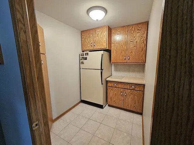 a kitchen with granite countertop cabinets and refrigerator