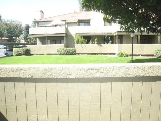 a view of a house with a yard and potted plants
