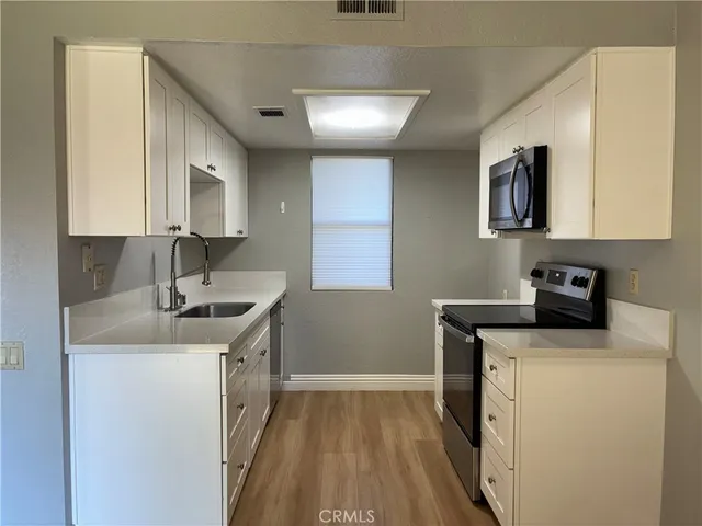 a kitchen with a sink stove and cabinets
