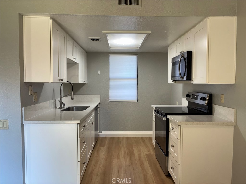 10151 Arrow Route, Unit 11 Rancho Cucamonga, CA 91730 - Photo 9 of 28 a kitchen with a sink stove and cabinets