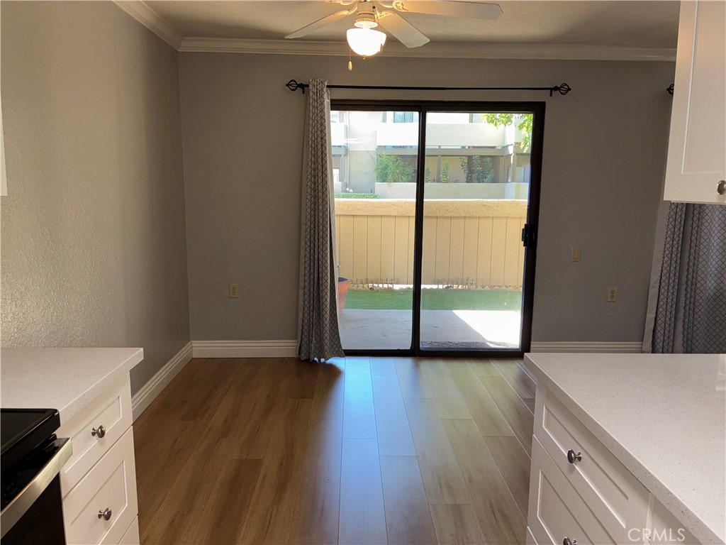 10151 Arrow Route, Unit 11 Rancho Cucamonga, CA 91730 - Photo 10 of 28 a view of an empty room with wooden floor and a window