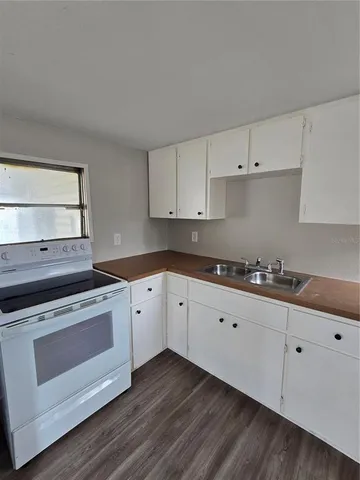 a kitchen with granite countertop white cabinets and white appliances