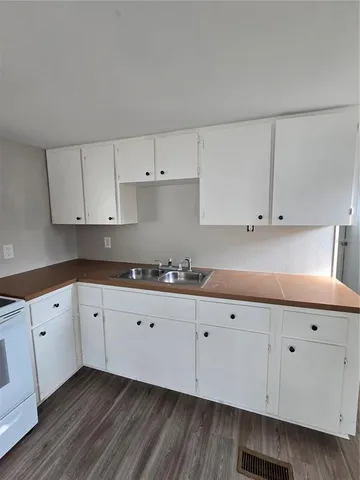 a kitchen with granite countertop white cabinets and a sink