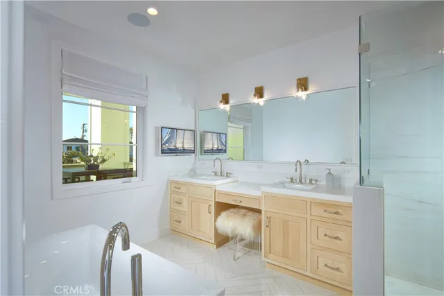 a spacious bathroom with a double vanity sink a mirror and a bathtub